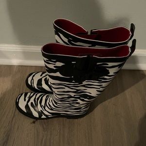 Zebra print rain boots lined in red.